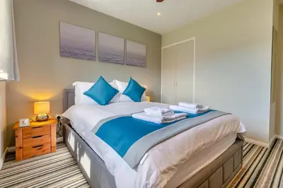 a bedroom with a large bed with blue pillows at 2 Bed in St. Merryn oc-l29063 in St Merryn