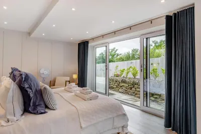 a bedroom with a large bed and a large window at 6 Bed in High Lanes oc-r29370 in Little Petherick