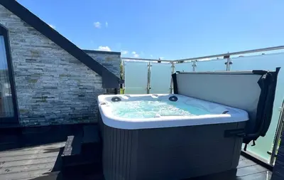 a hot tub on the balcony of a house at 6 Bed in High Lanes oc-r29370 in Little Petherick