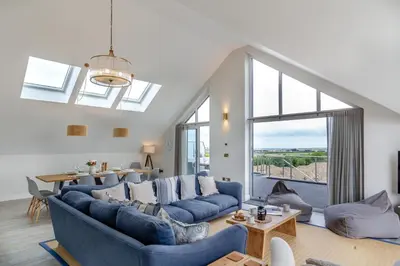 a living room with blue couches and a large window at 6 Bed in High Lanes oc-r29370 in Little Petherick