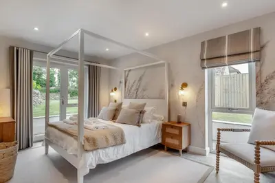 a white bedroom with a canopy bed and a chair at 6 Bed in High Lanes oc-r29370 in Little Petherick