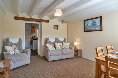 a living room with two chairs and a table at Finest Retreats - Cutkieve Farm Cottage in Middlehill