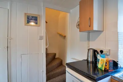 a small kitchen with a stairway leading into a room at Finest Retreats - Cutkieve Farm Cottage in Middlehill