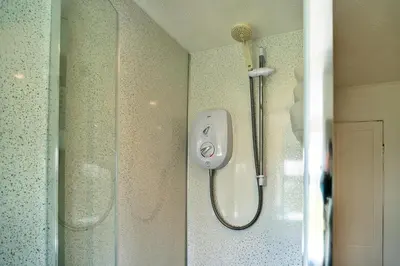 a shower with a shower head in a bathroom at Finest Retreats - Cutkieve Farm Cottage in Middlehill