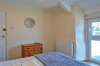 a bedroom with a bed and a dresser and a mirror at Finest Retreats - Cutkieve Farm Cottage in Middlehill