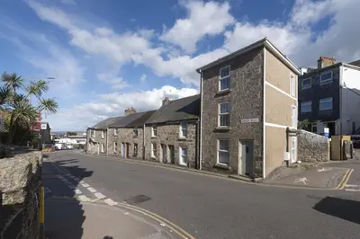 a row of brick buildings on a street at May Cottage in St Ives