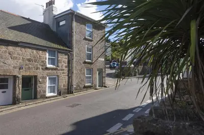 a palm tree in front of a building on a street at May Cottage in St Ives