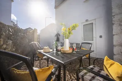 a table and chairs on a patio with a table at May Cottage in St Ives