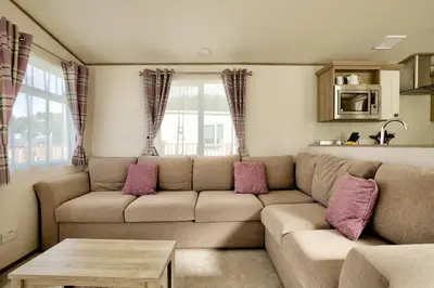 a living room with a couch and a table at 16 Lakeview, Pelham Retreat in Crantock