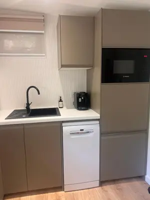 a small kitchen with a sink and a dishwasher at The Mill Lodge in Helston