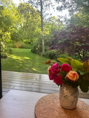a vase with flowers on a table on a porch at The Mill Lodge in Helston