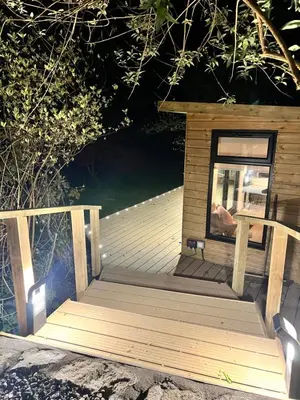 a wooden deck with a small house on it at The Mill Lodge in Helston