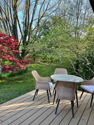 three chairs and a table on a wooden deck at The Mill Lodge in Helston