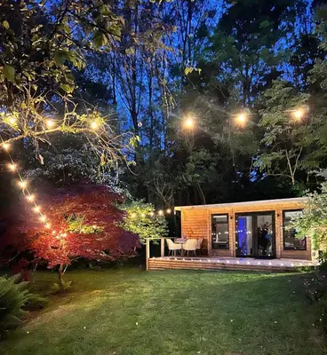 a tiny house in a garden at night at The Mill Lodge in Helston