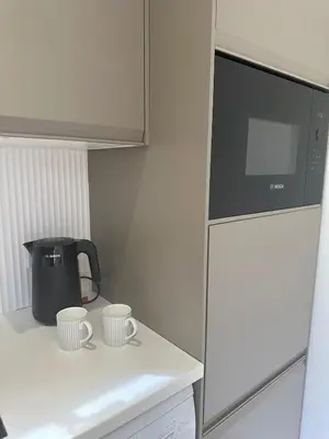 a kitchen with two cups on a counter with a refrigerator at The Mill Lodge in Helston