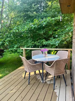 a table and two chairs on a wooden deck at The Mill Lodge in Helston