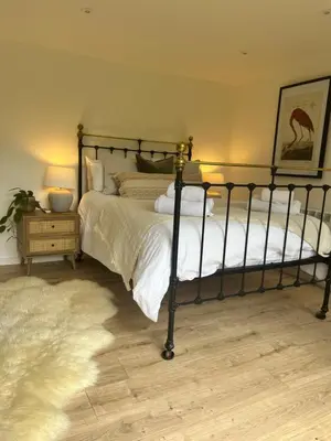 a bedroom with two beds with white sheets and a rug at The Mill Lodge in Helston