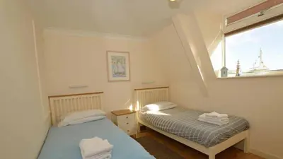 two beds in a small room with a window at Beach View House - Self Catering Hayle, St Ives Bay Cornwall in Hayle