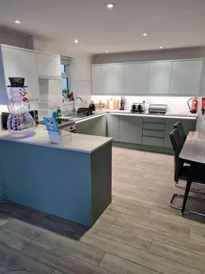 a large kitchen with white cabinets and a blue counter at Beach View House - Self Catering Hayle, St Ives Bay Cornwall in Hayle