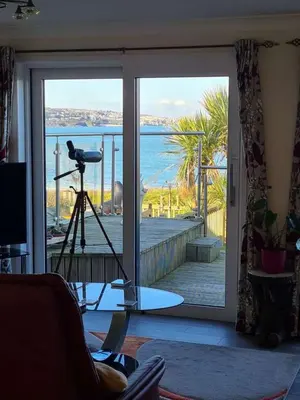 a room with a glass door with a view of the ocean at Beach View House - Self Catering Hayle, St Ives Bay Cornwall in Hayle