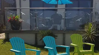 two blue and green chairs and an umbrella at Beach View House - Self Catering Hayle, St Ives Bay Cornwall in Hayle