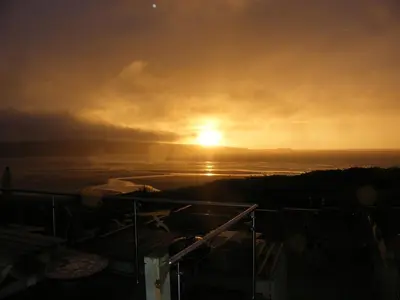 a sunset over the ocean with the sun in the sky at Beach View House - Self Catering Hayle, St Ives Bay Cornwall in Hayle