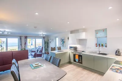 a kitchen and living room with a table and a dining room at Beach View House - Self Catering Hayle, St Ives Bay Cornwall in Hayle