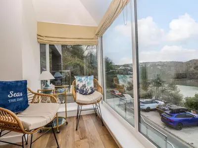 a room with a large window with a view of a car at Anjoma in Looe