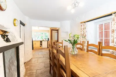 a kitchen and dining room with a wooden table at Lolgorien, West Cornwall, Sleeps 8 in Camborne