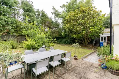 a patio with a table and chairs in a yard at Lolgorien, West Cornwall, Sleeps 8 in Camborne