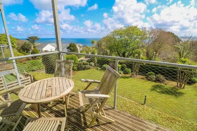 a deck with a table and two chairs on a balcony at Talland View in St Ives