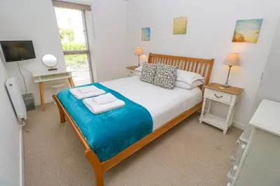 a bedroom with a bed with two pillows and a television at Talland View in St Ives
