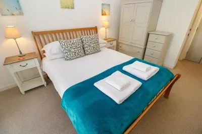 a bedroom with a bed with two towels on it at Talland View in St Ives