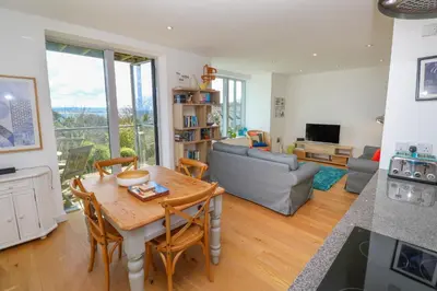 a living room with a table and a couch at Talland View in St Ives