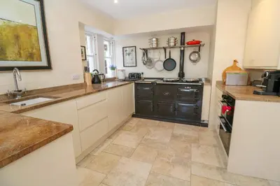 a large kitchen with white cabinets and a sink at Hindon Hall in St Ives