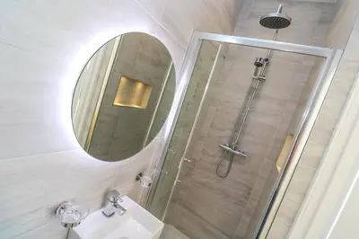 a bathroom with a shower and a sink and a mirror at Hindon Hall in St Ives