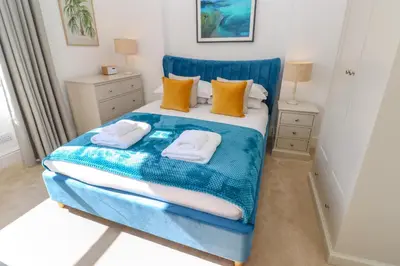 a bedroom with a blue bed with towels on it at Hindon Hall in St Ives
