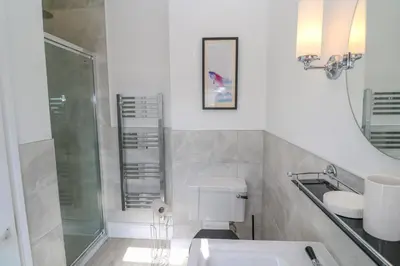 a bathroom with a shower and a toilet and a sink at Hindon Hall in St Ives