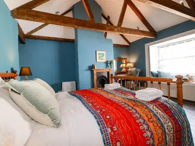 a bedroom with blue walls and a large bed at Carew House Cottage in Redruth