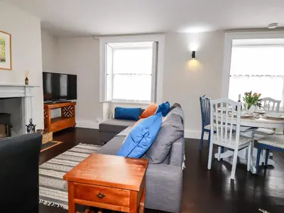 a living room with a couch and a table at Carew House Cottage in Redruth
