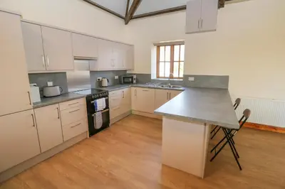 a large kitchen with white cabinets and a counter top at The Granary in Penzance