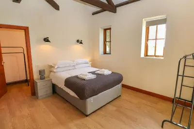 a bedroom with a bed with white sheets and pillows at The Granary in Penzance