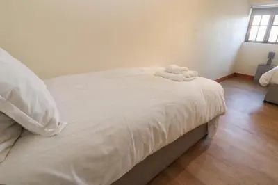 a white bed with a stuffed animal on top of it at The Granary in Penzance