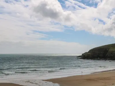 a beach with the ocean and a cloudy sky at The Granary in Penzance