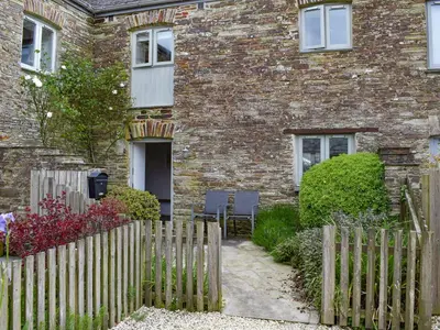 a brick house with a wooden fence in front of it at Pentire View in Padstow