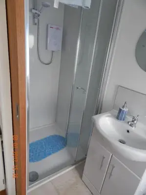 a bathroom with a shower and a sink at Rose's Cottage in Gorran Haven