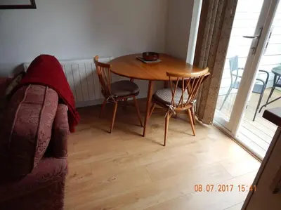 a living room with a table and chairs and a couch at Rose's Cottage in Gorran Haven