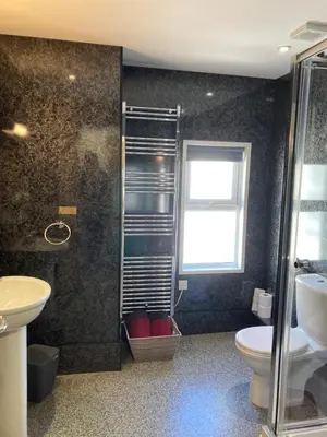 a bathroom with a shower and a toilet and a window at The Quies in Newquay