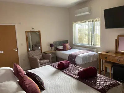 a hotel room with two beds and a desk at The Quies in Newquay