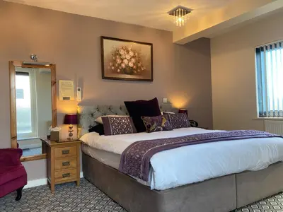 a bedroom with a large bed and a mirror at The Quies in Newquay